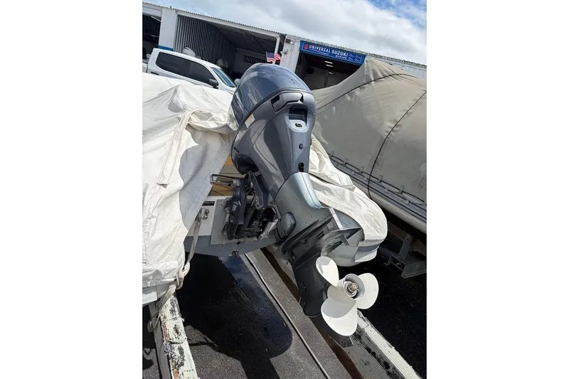 Slide: The Image of Outboard motor on a 2010 Nautica RIB 14 boat, covered and parked outdoors. - 2