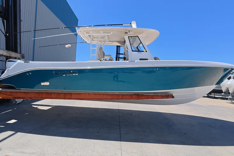 The Image of 2019 Everglades 335 Center Console boat in dry dock, blue hull, sunny day. - 0