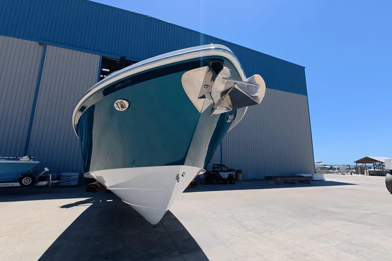 Slide: The Image of 2019 Everglades 335 Center Console boat in marina, showcasing sleek design and propeller. - 13