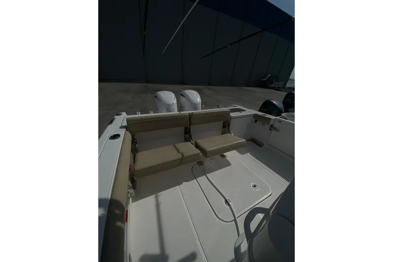 Slide: The Image of 2019 Everglades 335 Center Console boat with dual engines and beige seating. - 16