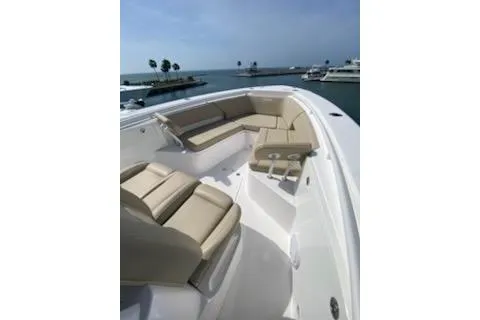 Slide: The Image of 2019 Everglades 335 Center Console boat interior with beige seating and modern design. - 6