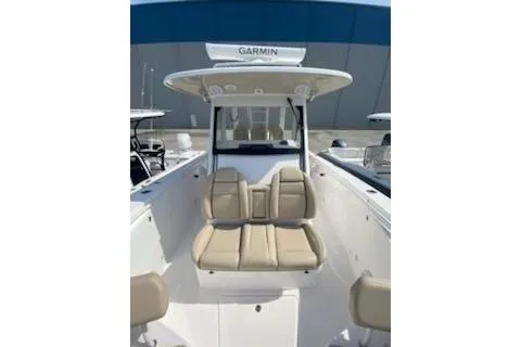 Slide: The Image of 2019 Everglades 335 Center Console boat with spacious seating, docked near palm trees and yachts. - 7