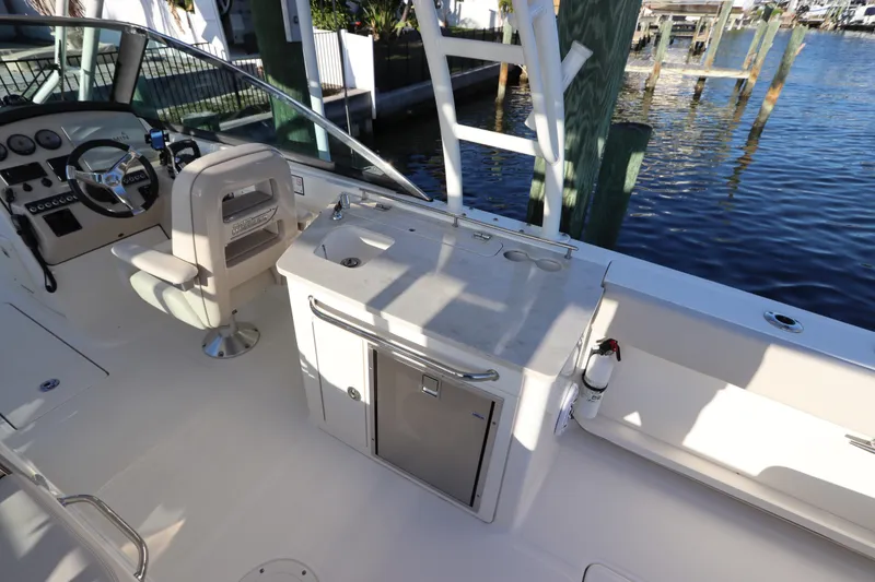 Slide: The Image of 2016 Boston Whaler 270 Vantage boat interior with helm and sink area. - 18
