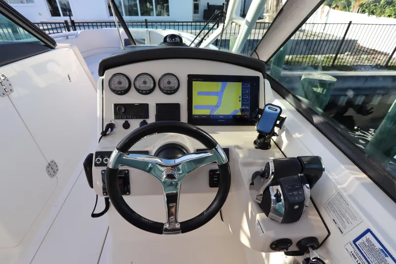 Slide: The Image of 2016 Boston Whaler 270 Vantage helm with steering wheel, gauges, and navigation display. - 23