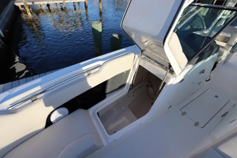 Slide: The Image of 2016 Boston Whaler 270 Vantage boat interior with open storage compartment by the water. - 33