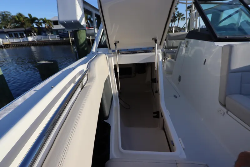 Slide: The Image of 2016 Boston Whaler 270 Vantage boat interior storage compartment open by the dock. - 34