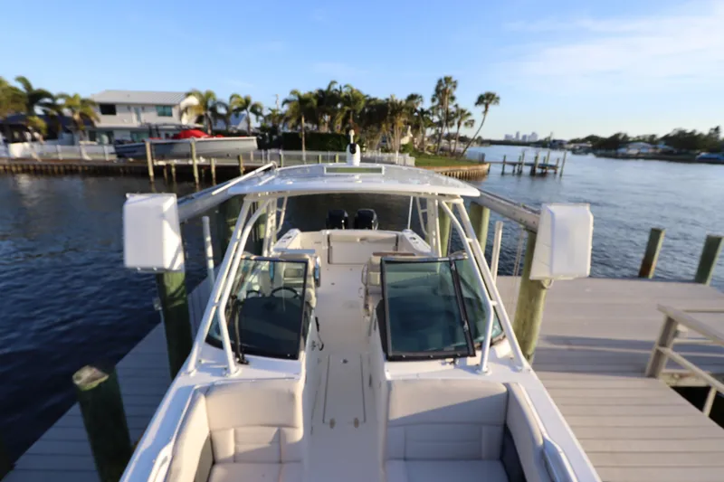 Slide: The Image of 2016 Boston Whaler 270 Vantage docked by waterfront homes and palm trees. - 35