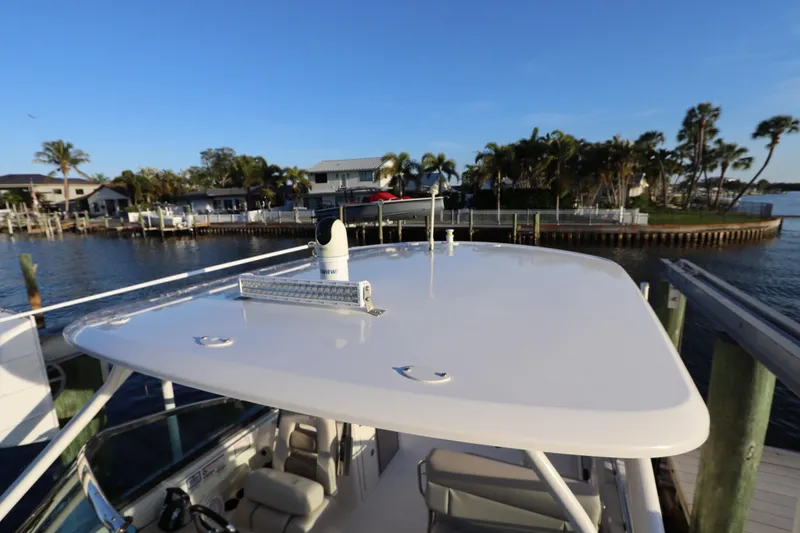 Slide: The Image of 2016 Boston Whaler 270 Vantage boat docked by waterfront homes and palm trees. - 36