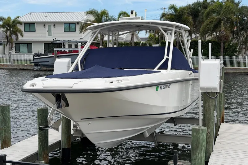 Slide: The Image of 2016 Boston Whaler 270 Vantage boat docked on a lift by waterfront homes. - 37