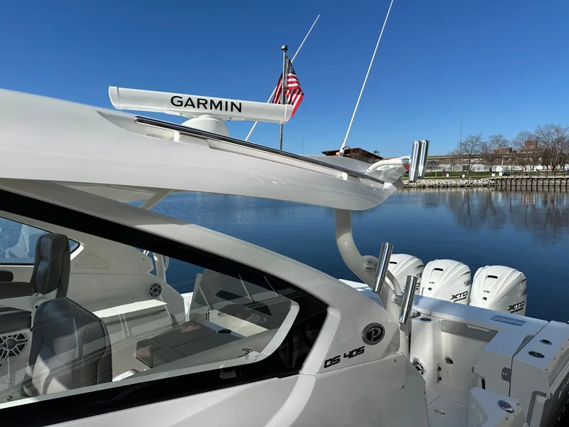 Slide: The Image of 2024 Pursuit OS405 boat with Garmin equipment on a calm lake. - 3