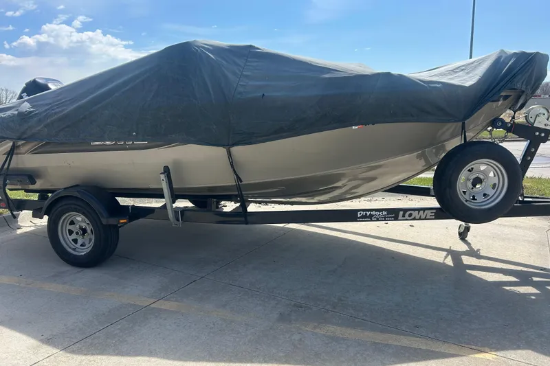 Slide: The Image of 2006 Lowe Fish & Ski 175 boat covered on trailer, parked outdoors. - 11