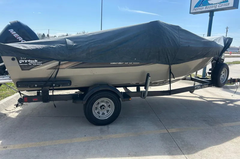 Slide: The Image of 2006 Lowe Fish & Ski 175 boat on trailer, covered with tarp, parked outdoors. - 12