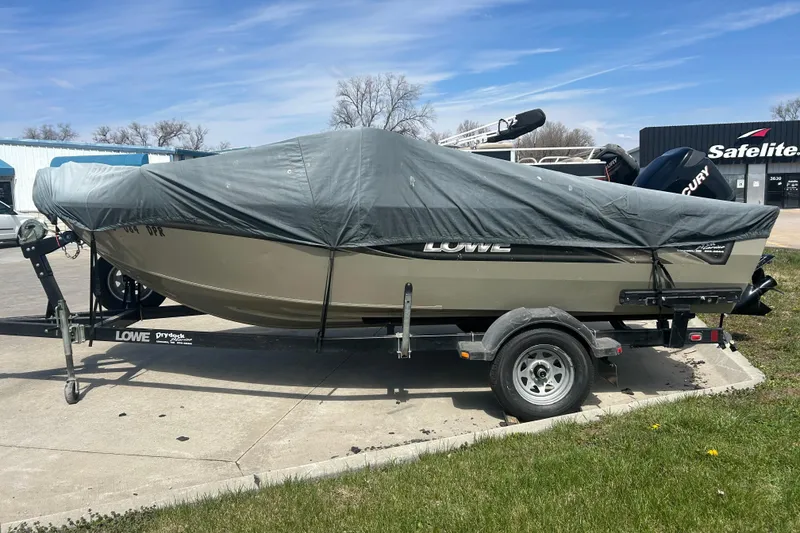 Slide: The Image of 2006 Lowe Fish & Ski 175 boat covered on trailer, parked outdoors. - 14