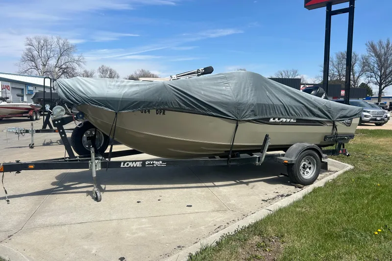 Slide: The Image of 2006 Lowe Fish & Ski 175 boat covered on trailer, parked outdoors. - 16