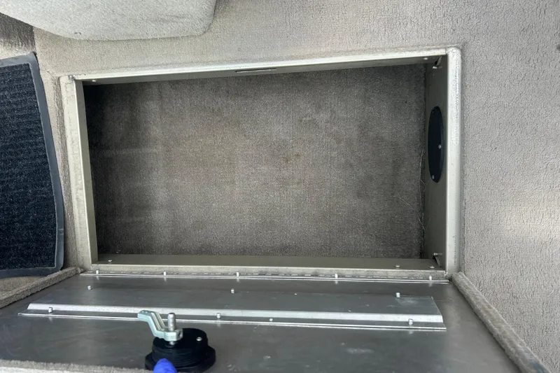 Slide: The Image of 2006 Lowe Fish & Ski 175 storage compartment with carpeted interior and metal latch. - 21