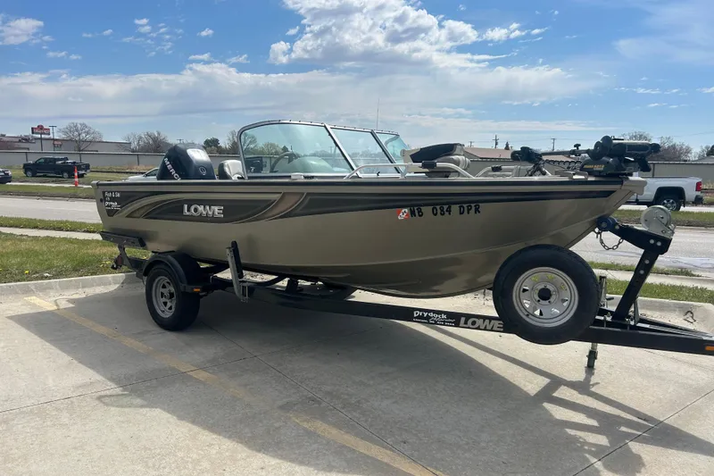 Slide: The Image of 2006 Lowe Fish & Ski 175 boat on trailer, parked outdoors under a partly cloudy sky. - 5