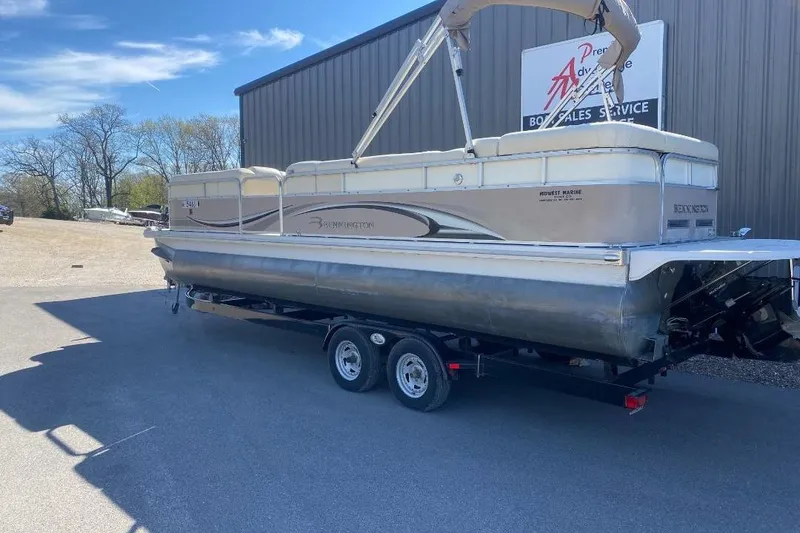 Slide: The Image of 2008 Bennington 2575RL I/O pontoon boat on trailer, parked outside a service building. - 3