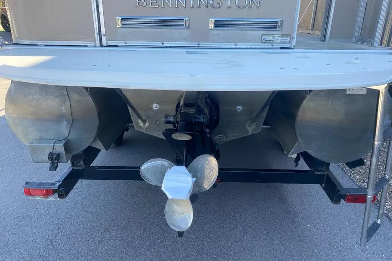 Slide: The Image of Rear view of a 2008 Bennington 2575RL I/O boat with visible propeller and pontoons. - 4