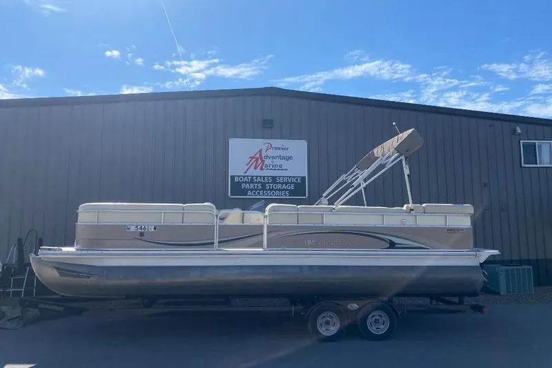 Slide: The Image of 2008 Bennington 2575RL I/O pontoon boat on trailer outside marine service building. - 5
