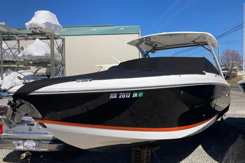 The Image of 2022 Cobalt R30 boat with black cover, parked outdoors under clear blue sky. - 0