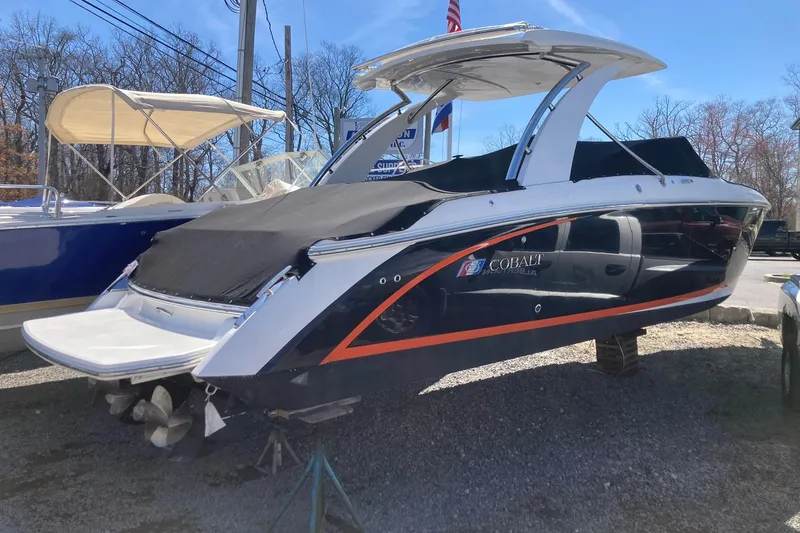Slide: The Image of 2022 Cobalt R30 boat with black cover, displayed outdoors on gravel. - 1