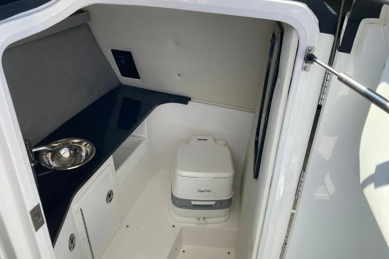 Slide: The Image of 2022 Cobalt R30 boat interior with compact toilet and sink. - 13