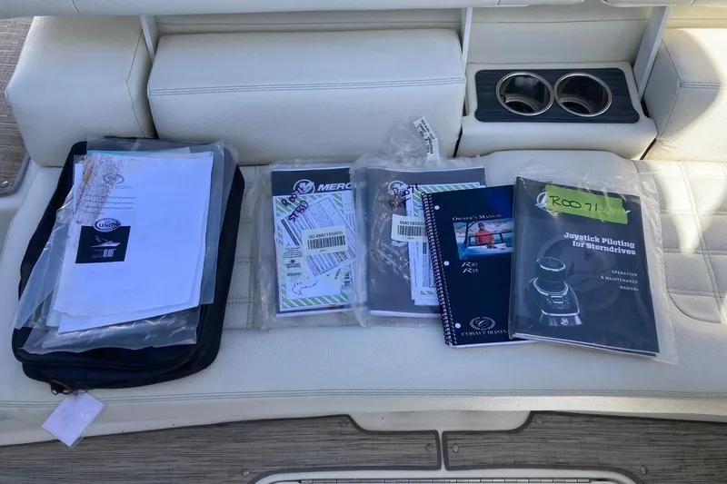 Slide: The Image of Boat manuals and documents on a Cobalt R30, 2022 model, placed on a white seat. - 16