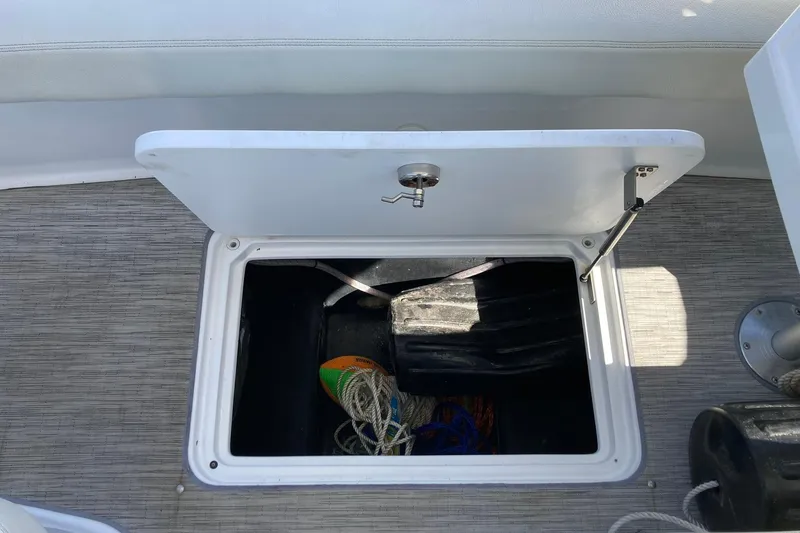 Slide: The Image of Open storage compartment on 2022 Cobalt R30 boat, containing ropes and equipment. - 17