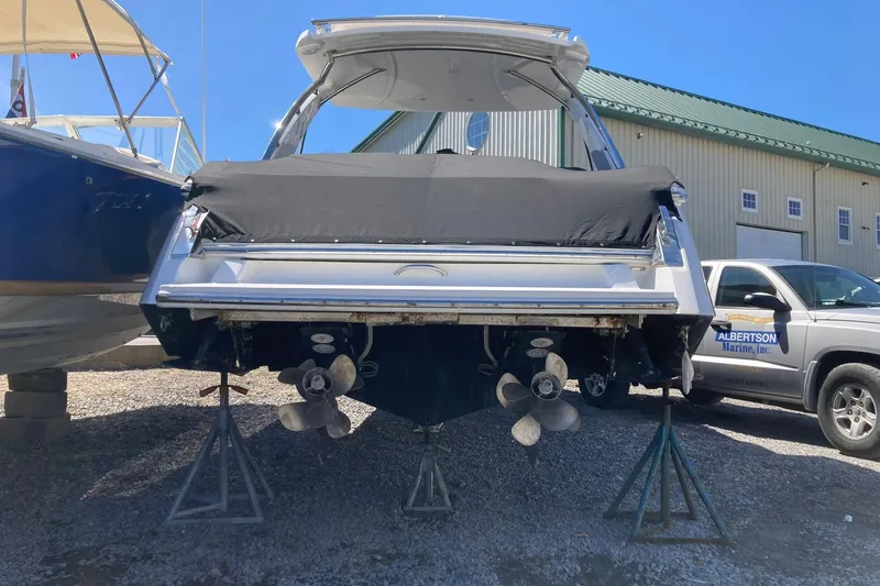 Slide: The Image of 2022 Cobalt R30 boat on stands, covered, near Albertson Marine truck. - 2