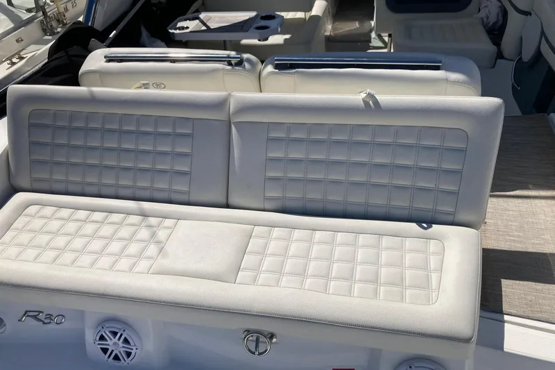 Slide: The Image of 2022 Cobalt R30 boat interior with white cushioned seating and stylish design. - 22