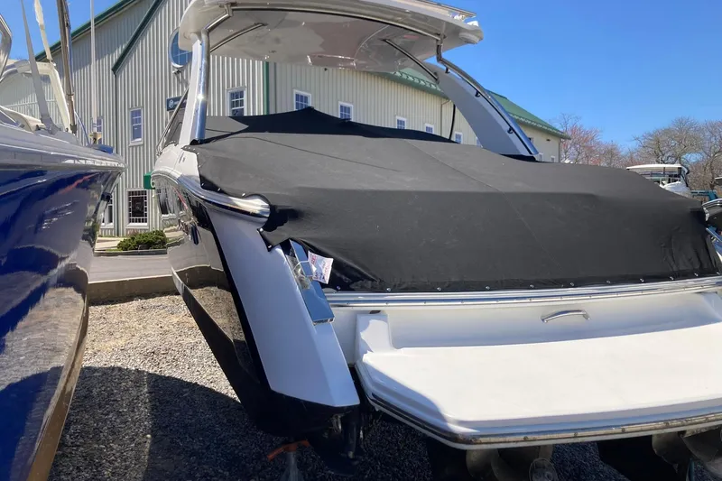 Slide: The Image of 2022 Cobalt R30 boat covered, parked outdoors near a building. - 4