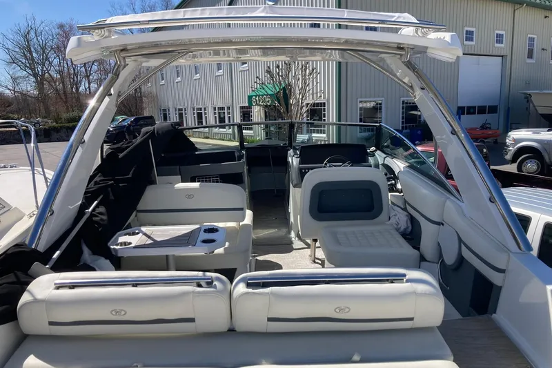 Slide: The Image of 2022 Cobalt R30 boat interior with seating and helm, parked near a building. - 9