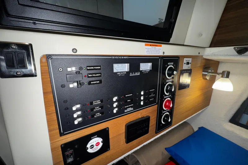 Slide: The Image of Electrical control panel inside 2026 Ranger Tugs R-25 boat cabin, featuring switches and gauges. - 11