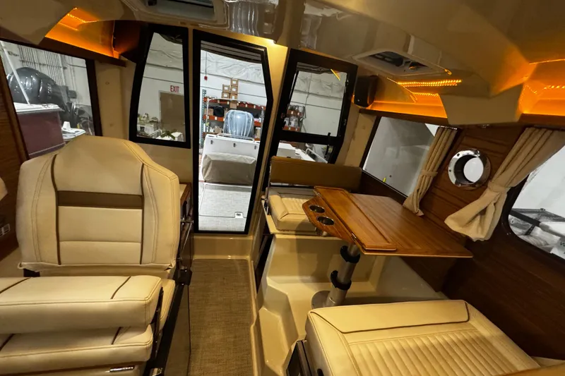 Slide: The Image of Interior of 2026 Ranger Tugs R-25 boat with seating and wooden table. - 12