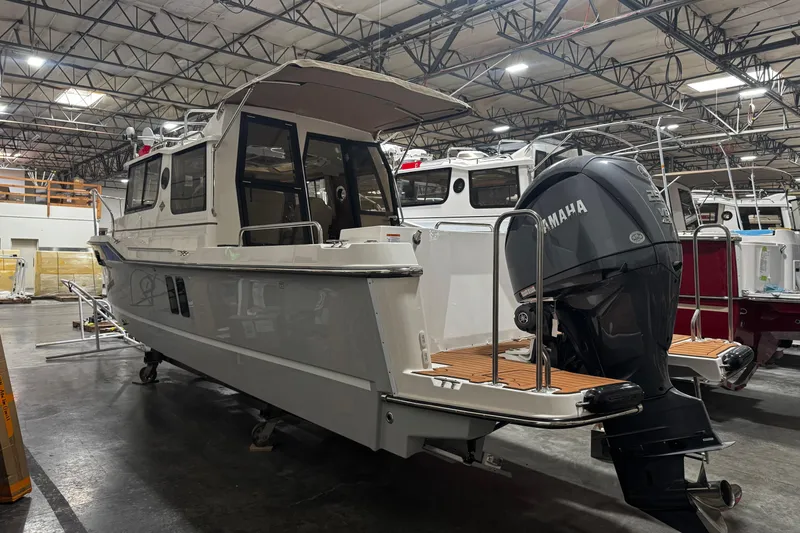 Slide: The Image of 2026 Ranger Tugs R-25 boat with Yamaha outboard motor in a warehouse setting. - 4