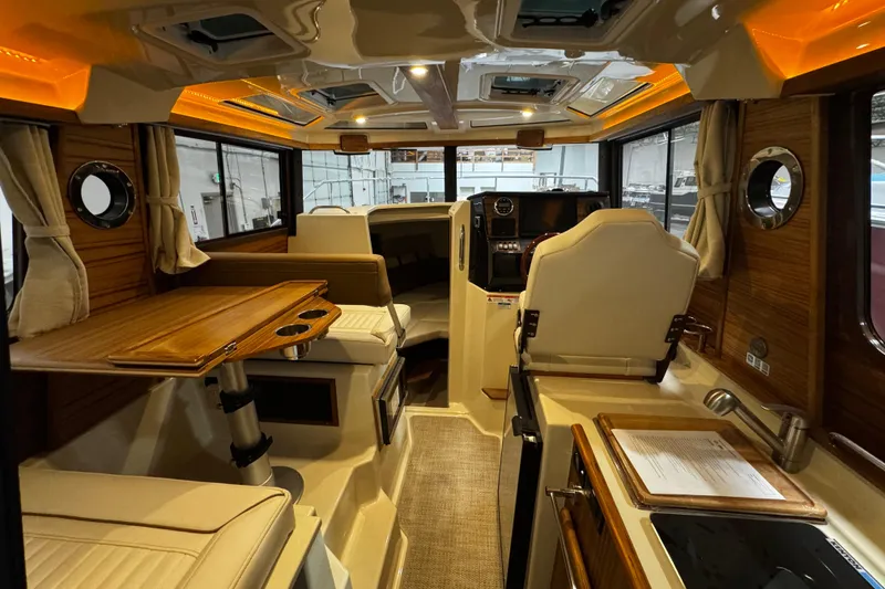 Slide: The Image of Interior of 2026 Ranger Tugs R-25 boat, featuring elegant wood finishes and modern amenities. - 6