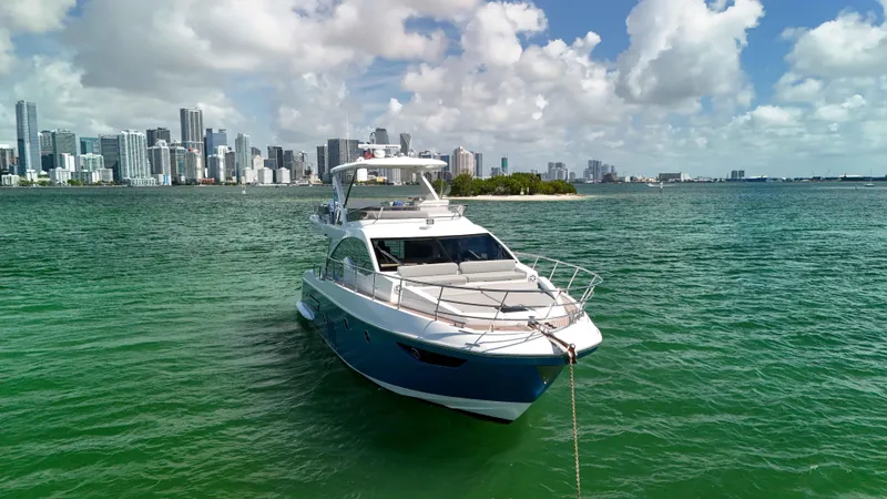 Slide: The Image of Azimut 50 Flybridge 2016 yacht anchored near city skyline, clear skies, and green waters. - 12