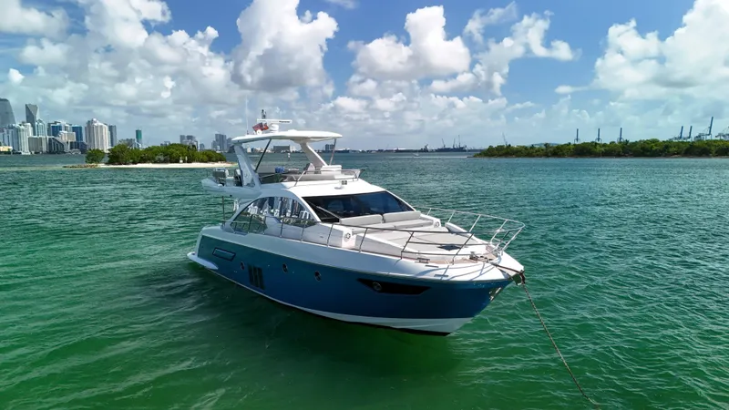 Slide: The Image of 2016 Azimut 50 Flybridge yacht on turquoise water with city skyline in background. - 13