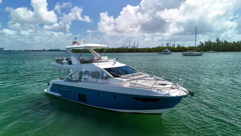 Slide: The Image of 2016 Azimut 50 Flybridge yacht on calm water under a partly cloudy sky. - 14