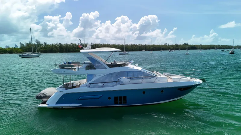 Slide: The Image of 2016 Azimut 50 Flybridge yacht cruising on a sunny day in a scenic bay. - 15