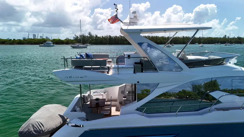 Slide: The Image of Azimut 50 Flybridge 2016 yacht on serene water with clear skies and distant boats. - 18
