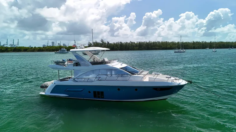 Slide: The Image of Azimut 50 Flybridge 2016 yacht on serene water with cloudy sky backdrop. - 2