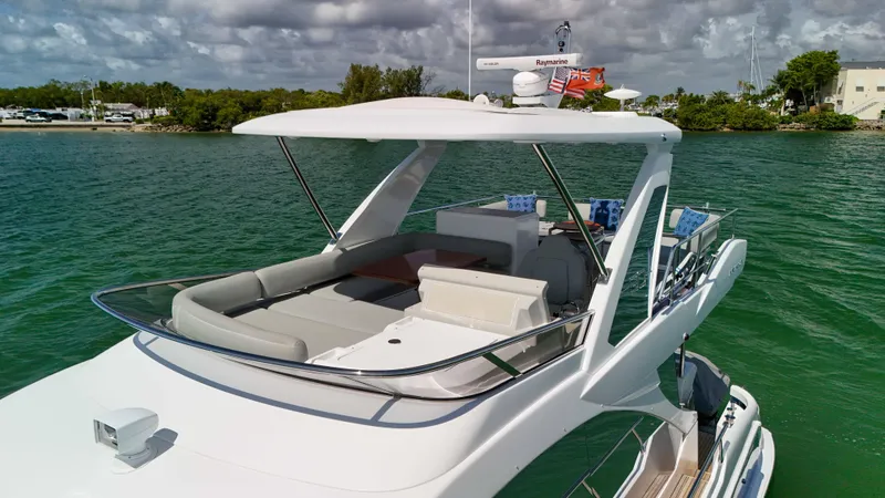 Slide: The Image of 2016 Azimut 50 Flybridge yacht on calm water, featuring spacious deck and modern design. - 25