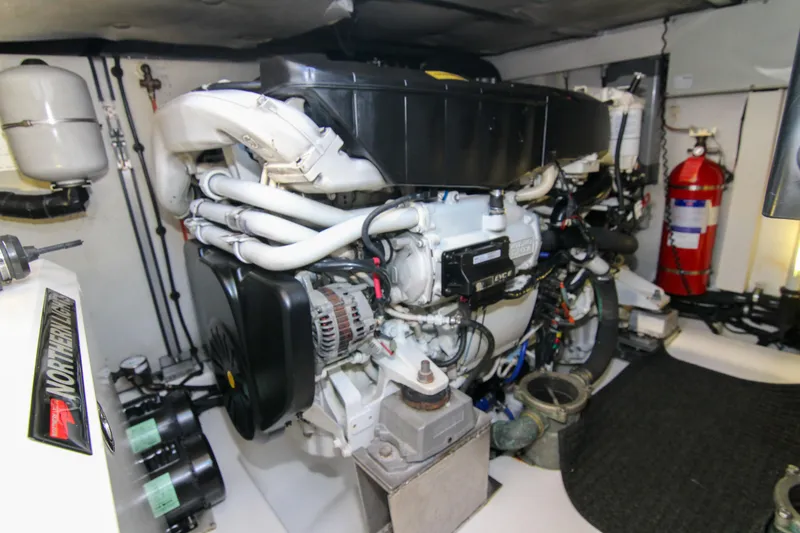 Slide: The Image of Engine room of 2016 Azimut 50 Flybridge yacht, featuring complex machinery and fire extinguisher. - 38