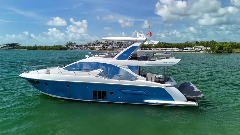 Slide: The Image of 2016 Azimut 50 Flybridge yacht on calm water under a partly cloudy sky. - 7