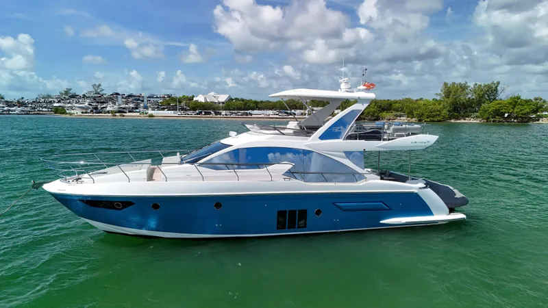 Slide: The Image of 2016 Azimut 50 Flybridge yacht on clear water under a partly cloudy sky. - 9