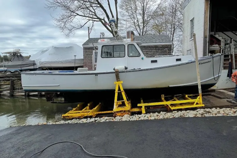 Slide: The Image of 2007 Northern Bay 36 boat on dry dock, surrounded by trees and equipment. - 2