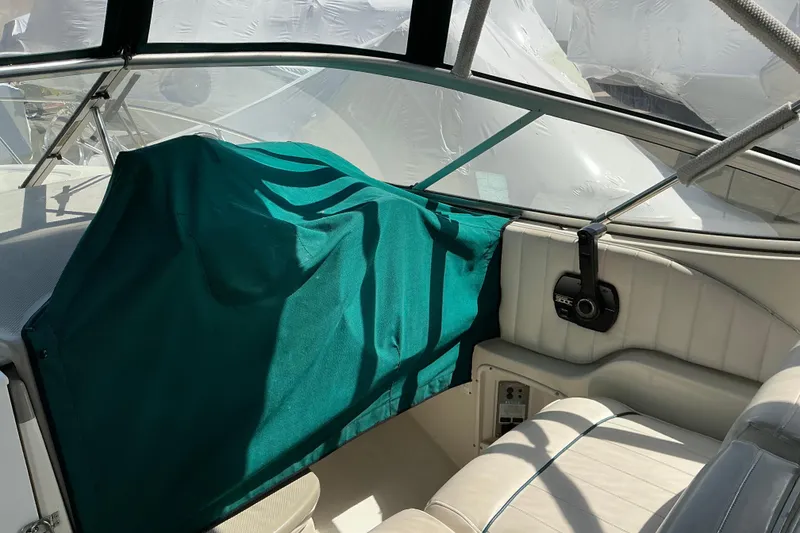 Slide: The Image of Interior of a 1997 Maxum 2700 SCR boat with green cover and white seating. - 10