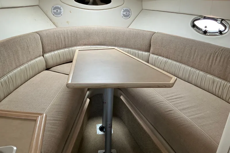 Slide: The Image of Interior of 1997 Maxum 2700 SCR boat with beige seating and table. - 17