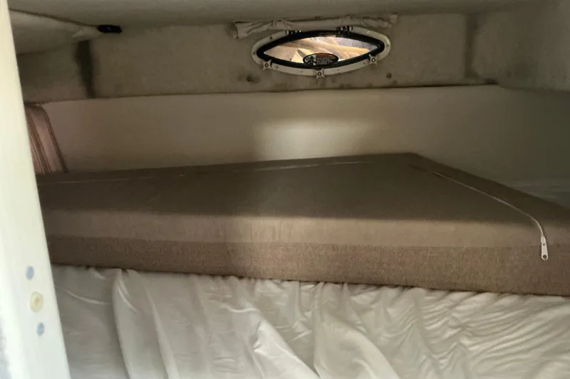 Slide: The Image of 1997 Maxum 2700 SCR cabin interior with bed and small window. - 19